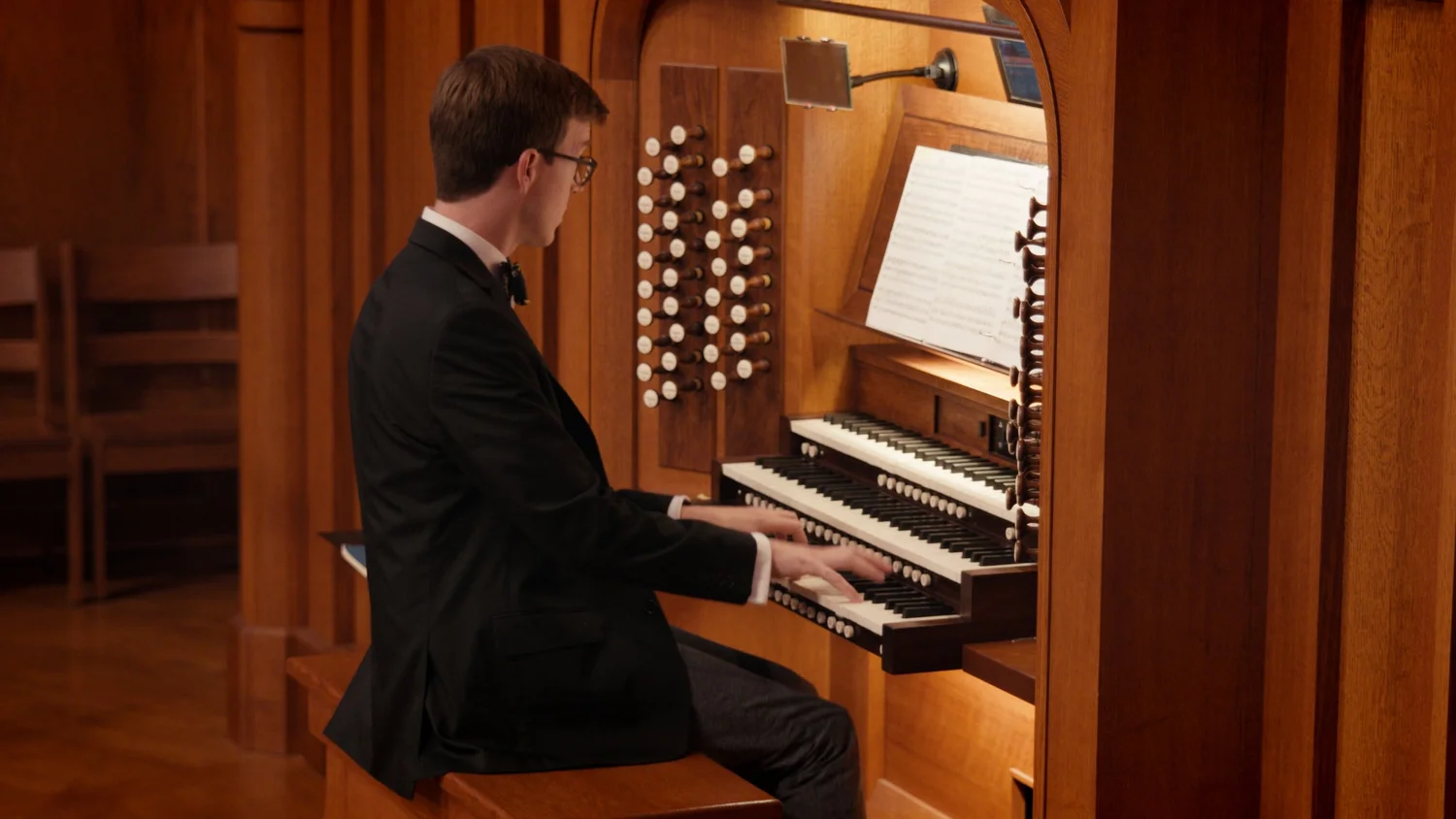 Organist performing in a wood-paneled sanctuary